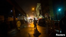 Bomberos trabajan durante la noche en el sitio de la explosión en Harlem, Nueva York.