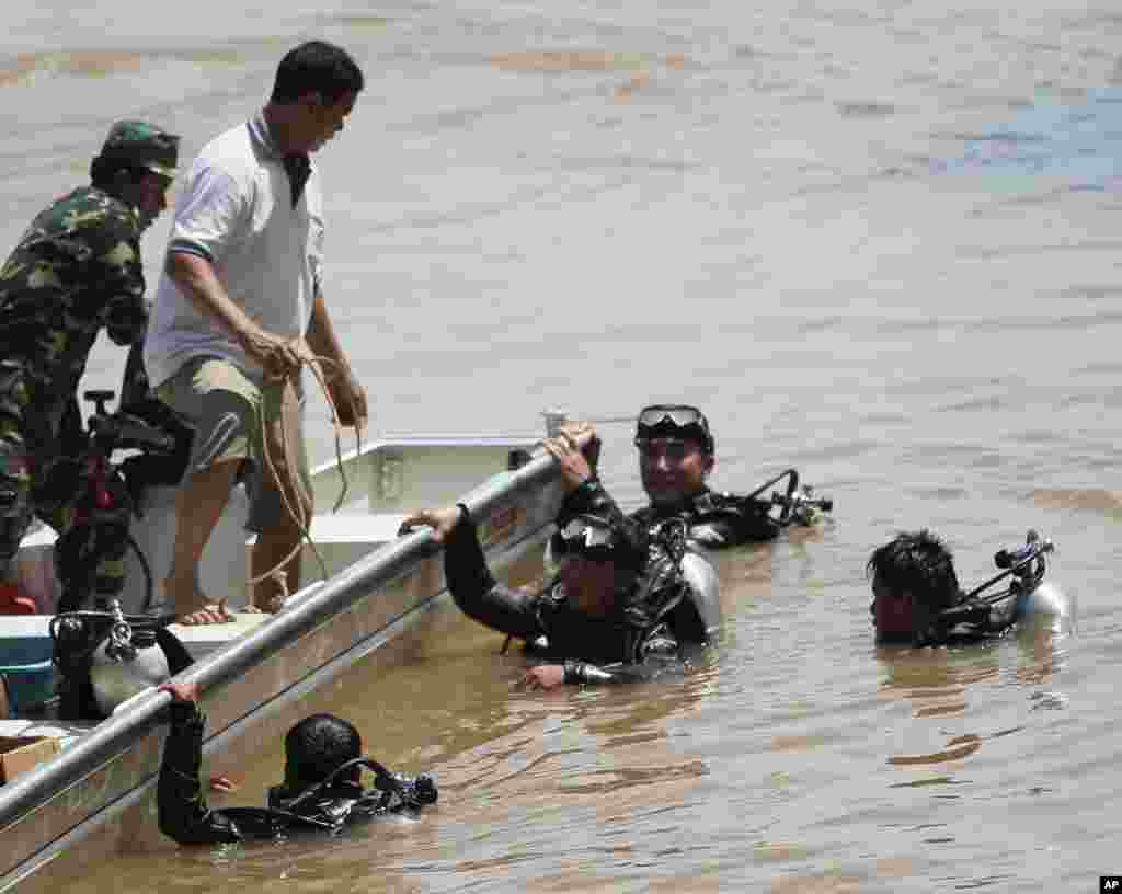 Divers search for bodies of victims of a crashed Lao Airlines plane in the Mekong River in Pakse, Laos, Oct. 17, 2013.