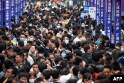 大批青年在重庆举办的一个招聘会上寻找工作。（2023年4月11日）
