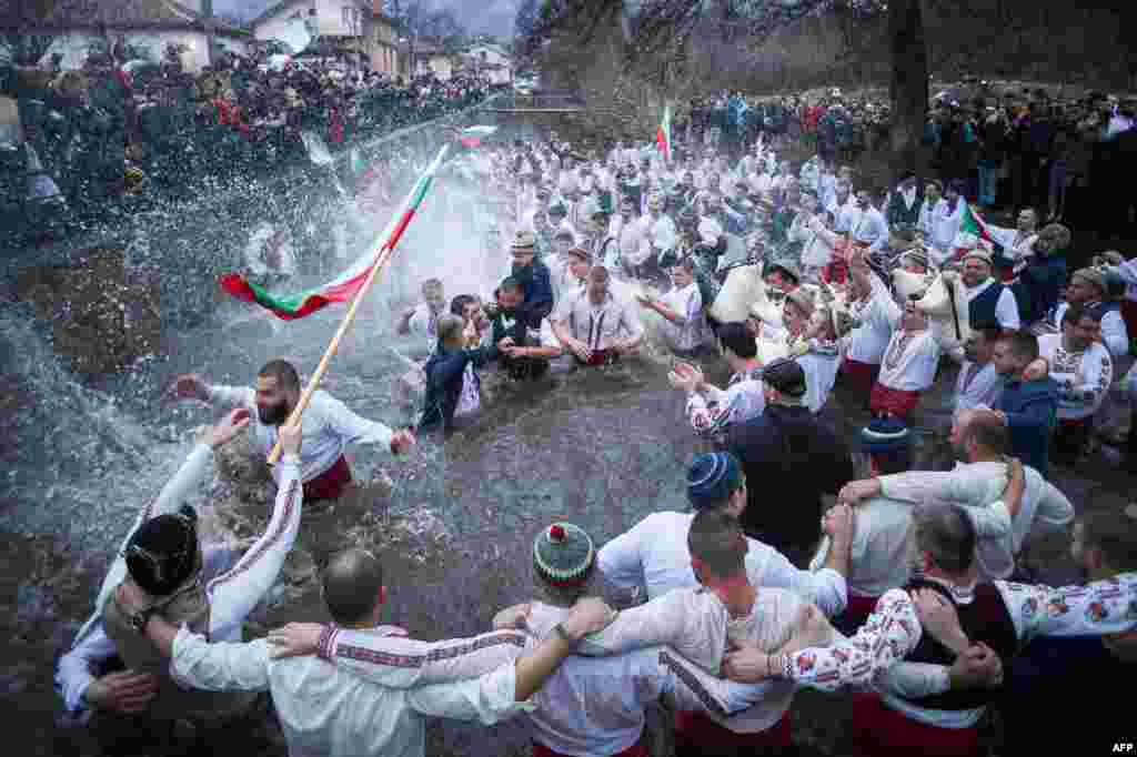 Men perform the traditional "Horo" dance in the icy winter waters of the Tundzha river in the town of Kalofer, as part of Epiphany Day celebrations despite the Covid-19 restrictions in the country.
