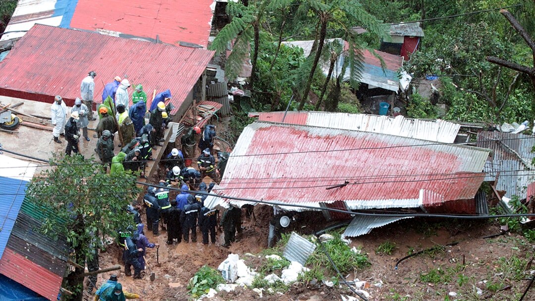 Tim SAR melakukan pencarian korban yang terkubur tanah longsor yang dipicu oleh badai tropis KOmpasu di Baguio, Filipina, 12 Oktober 2021. (AP)