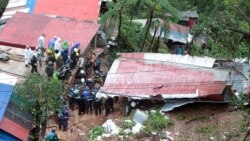 Tim SAR melakukan pencarian korban yang terkubur tanah longsor yang dipicu oleh badai tropis KOmpasu di Baguio, Filipina, 12 Oktober 2021. (AP)