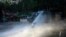 An anti-government protester, holding a Mapuche flag, is brought down by the jet spray of a police water cannon, in Santiago, Chile, Oct. 31, 2019.