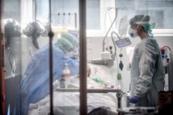 FILE - Medical personnel at work in the intensive care unit of the hospital of Brescia, Italy, March 19, 2020.
