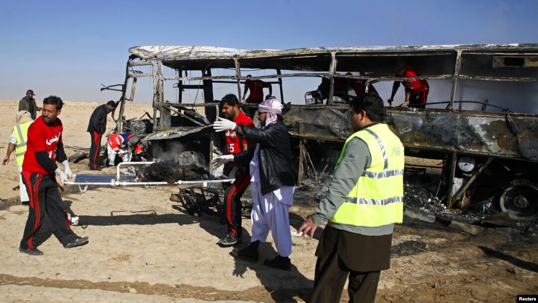 Para petugas mengangkat sisa-sisa jenazah para peziarah Syiah yang terbakar dari dalam bus di Quetta, Pakistan (30/12). Iring-iringan bis para peziarah Syiah ke Iran menjadi target bom yang diledakkan dari jarak jauh. Dilaporkan 20 orang tewas dan sedikitnya 24 terluka dalam insiden ini.