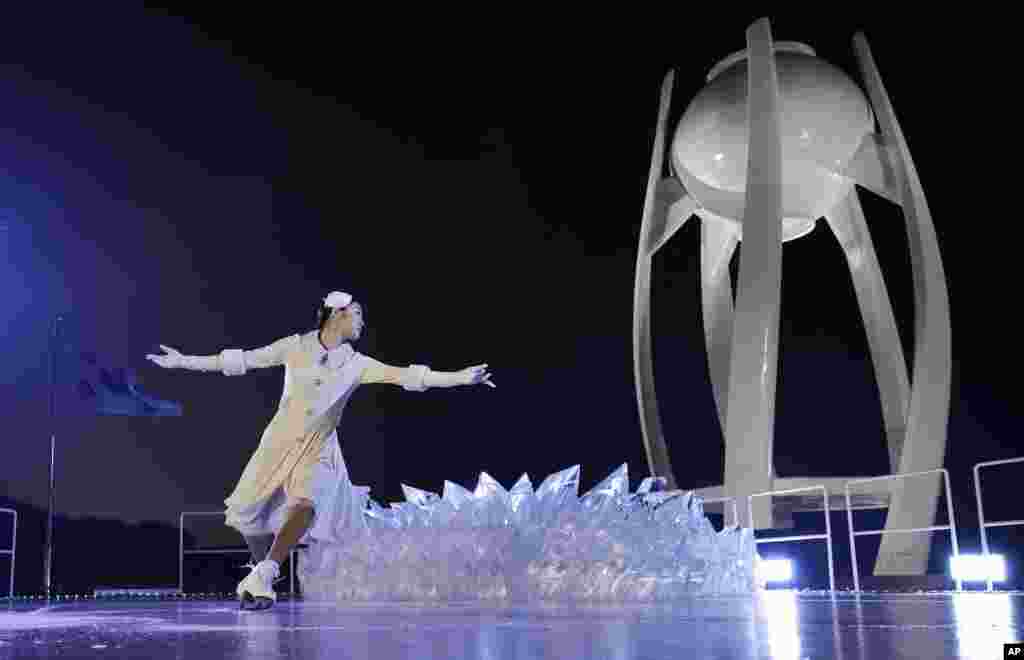 在平昌冬奥会开幕式上，韩国花样滑冰女神金妍儿在接过奥运火炬之前，在主火炬台旁边表演。