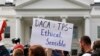 FILE - A person holds up a sign in support of the Deferred Action for Childhood Arrivals, known as DACA, and Temporary Protected Status programs during a rally in support of DACA and TPS outside of the White House, in Washington.