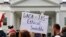 FILE - A person holds up a sign in support of the Deferred Action for Childhood Arrivals, known as DACA, and Temporary Protected Status programs during a rally in support of DACA and TPS outside of the White House, in Washington.