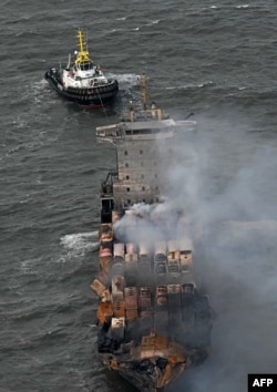 Asap mengepul dari kontainer yang rusak di dek kapal kargo MV Solong di Laut Utara, di lepas pantai Withernsea, sebelah timur Inggris, 11 Maret 2025, setelah bertabrakan dengan kapal tanker MV Stena Immaculate pada 10 Maret. (Paul ELLIS / AFP)