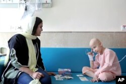 Taha Shakouri, an 8-year-old boy suffering from liver cancer, plays cards at Mahak Children's Hospital in Tehran, June 19, 2019.