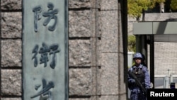 资料照：一名日本自卫队成员在东京防卫省入口处执勤(2026年4月6日)