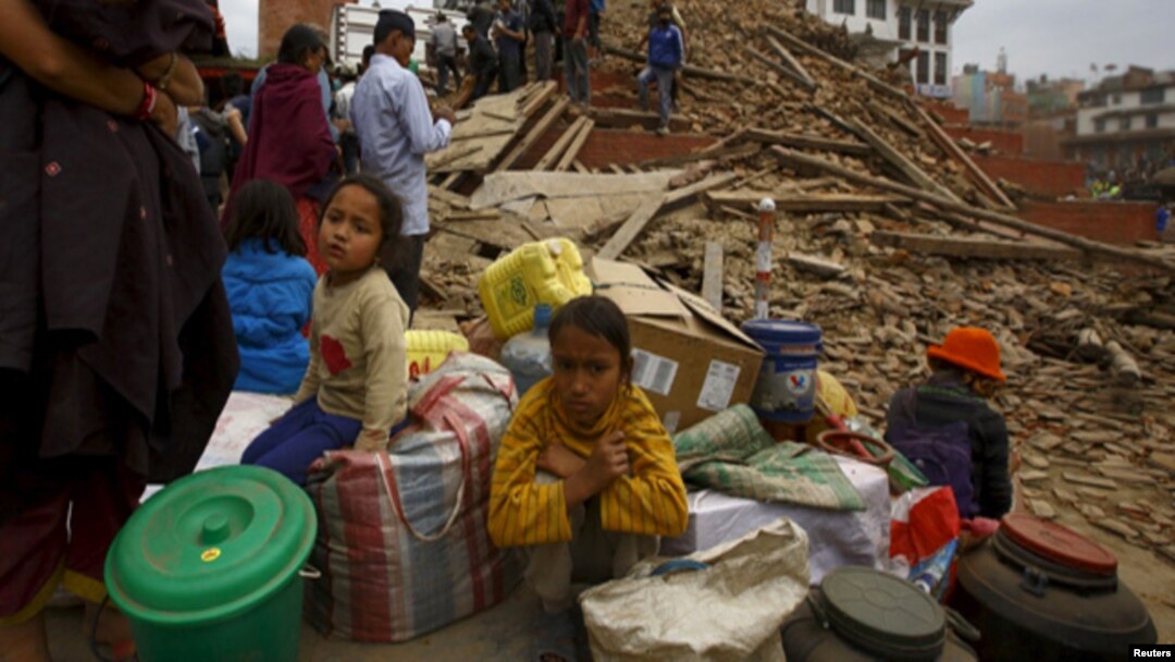 Warga duduk dengan barang-barang miliknya di luar sebuah kuil yang hancur di Alun-alun Bashantapur Durbar setelah gempa di Kathmandu, Nepal (25/4). (Reuters/Navesh Chitrakar)
