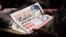 An Egyptian man holds a newspaper near Mesaha Square, in Cairo , Thursday, July 4, 2013.