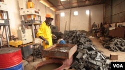 Inside Nelson Boateng's Nelplast factory in the outskirts of Accra, Ghana, a worker creates bricks from recycled plastic and sand, Nov. 12, 2019. (Stacey Knott/VOA)