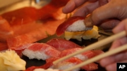 Pelanggan mengambil sushi tuna sirip biru yang dibeli oleh restoran sushi Kiyoshi Kimura, 5 Januari 2014. (Foto: AP/Shizuo Kambayashi)