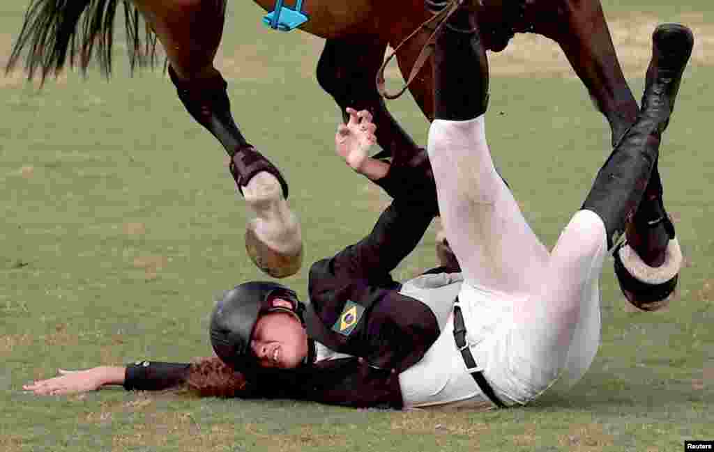 Ieda Guimaraes of Brazil falls from her horse during the equestrian portion of the women&#39;s modern pentathlon at the 2020 Summer Olympics, in Tokyo, Japan. 