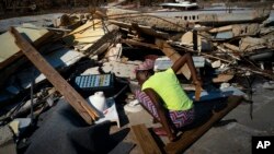 Seorang perempuan berusaha mencari anggota keluarganya yang masih hilang di antara reruntuhan bangunan akibat badai Dorian, di High Rock, Grand Bahama, Bahama. 