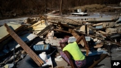 A woman searches for missing family members in the wreckage of her home, destroyed by Hurricane Dorian, in High Rock, Grand Bahama, Bahamas, Sept. 6, 2019.