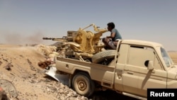 FILE - A Yemeni government fighter fires a vehicle-mounted weapon at a frontline position during fighting against Houthi fighters in Marib, Yemen, March 28, 2021.