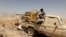 FILE - A Yemeni government fighter fires a vehicle-mounted weapon at a frontline position during fighting against Houthi fighters in Marib, Yemen, March 28, 2021.