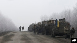 FILE - Ukrainian military convoy stops between the towns of Dabeltseve and Artemivsk, Feb. 14, 2015.