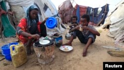 An internally displaced Somali girl prepares the traditional Somali breakfast "Anjero" at Sayyidka camp in the Howlwadag district, south of Somalia's capital Mogadishu, May 3, 2013. 