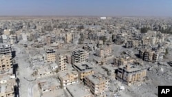 FILE - This frame grab made from drone video shows damaged buildings in Raqqa, Syria, Oct. 19, 2017.