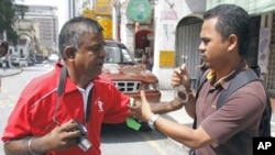 A plainclothes policeman tries to handcuff an activist as he defies police orders to disperse during a May Day rally in Kuala Lumpur May 1, 2010.