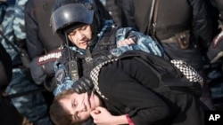 Arhia - Pripadnik ruske policije privodi demonstranta u Moskvi, 26. marta 2017.