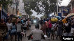 La gente camina en un mercado callejero de Petion-Ville mientras las motocicletas pasan, en Puerto Príncipe, Haití, 24 de julio de 2021. REUTERS / Ricardo Arduengo