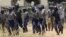 FILE: Police leave a scene after throwing teargas at a house in Chitungwiza, Zimbabwe, Sunday, Nov. 6, 2011. 