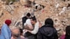 Displaced residents hug as they stand in front of the rubble of their destroyed house in Baalbek, eastern Lebanon, Nov. 28, 2024. 