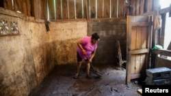 Una mujer limpia su casa del lodo que se originó por el desbordamiento del río después de que el huracán Julia azotara y arrojara fuertes lluvias en La Cruz, Nicaragua, el 10 de octubre de 2022.