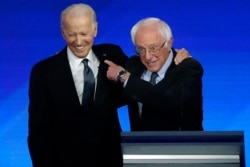 Former Vice President Joe Biden, left, embraces Sen. Bernie Sanders, I-Vt., during a Democratic presidential primary debate, Feb. 7, 2020, hosted by ABC News, Apple News, and WMUR-TV at Saint Anselm College in Manchester, N.H.