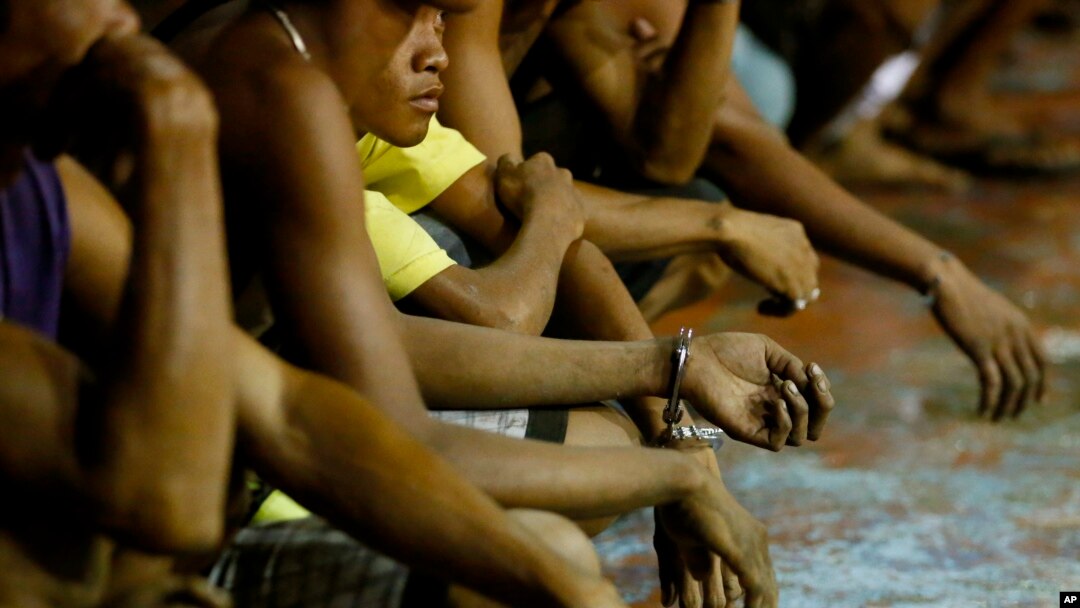 Warga yang ditangkap kebanyakan laki-laki, menunggu untuk dibawa ke kantor polisi dalam pelaksanaan operasi dari kampanye "Perang Terhadap Narkoba" Presiden Rodrigo Duterte, di komunitas kumuh Tondo, di Manila, Filipina, 30 September, 2016. (Foto: dok).