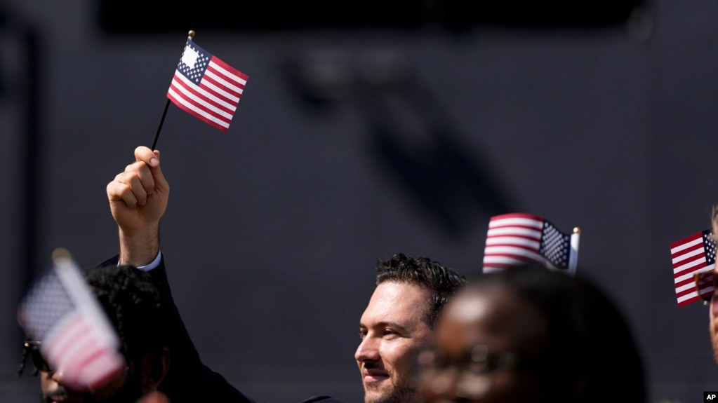 FILE - A man, part of a group of 50 new United States citizens, takes part in a naturalization ceremony before the San Diego Padres host the Minnesota Twins in a baseball game at Petco Park, Wednesday, Aug. 21, 2024, in San Diego. (AP Photo/Gregory Bull)