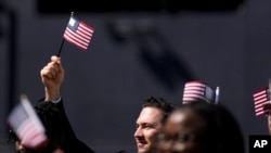 FILE - A man, part of a group of 50 new United States citizens, takes part in a naturalization ceremony before the San Diego Padres host the Minnesota Twins in a baseball game at Petco Park, Wednesday, Aug. 21, 2024, in San Diego. (AP Photo/Gregory Bull)