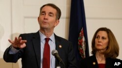 Virginia Gov. Ralph Northam, left, gestures as his wife, Pam, listens during a news conference in the Governors Mansion at the Capitol in Richmond, Va., Feb. 2, 2019. 