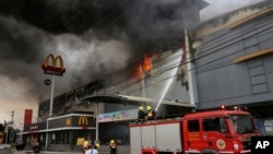 Firemen battle a fire that rages at a shopping mall, Dec. 23, 2017, in Davao city, southern Philippines. 