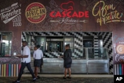 FILE - Waiters serve in a restaurant at Tatu City, a startup city that tries to tackle Africa's problem of urbanizing, in Nairobi, Kenya, Oct. 25, 2024.