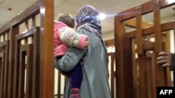 This file photo taken on February 19, 2018, shows French Jihadist Melina Boughedir carrying her son as she arrives to court in the Iraqi capital Baghdad.