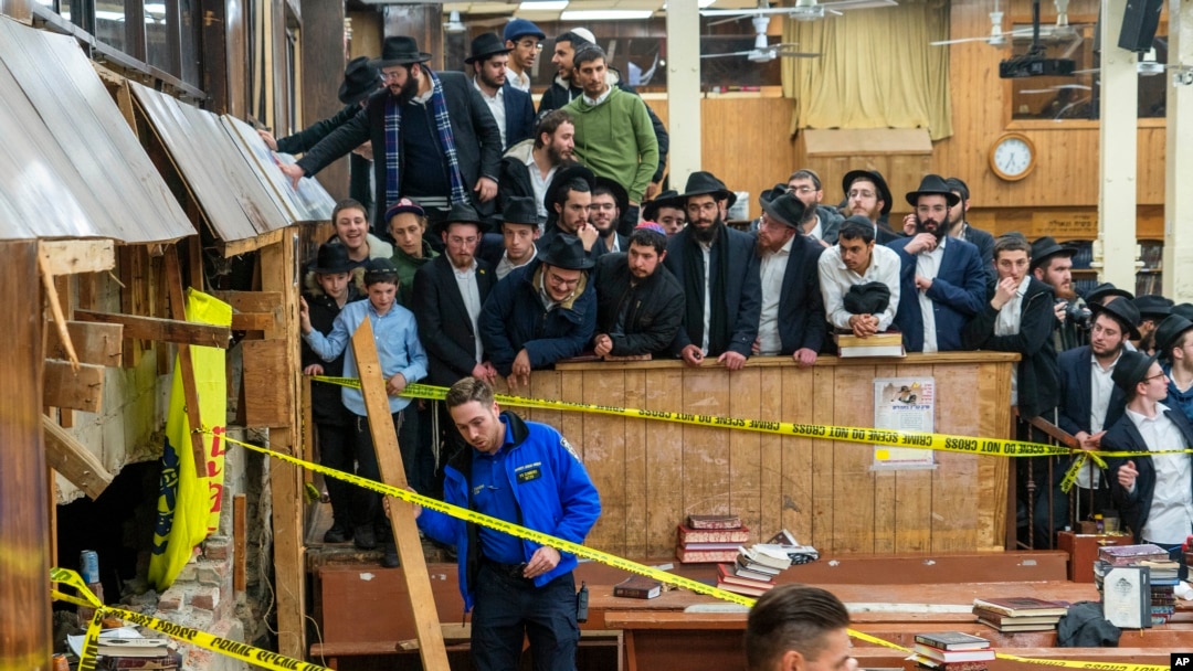 Hasidi posmatraju kako policija pravi obezbeđuje deo zida sinagoge koji vodi ka tunelu koji su hasidski studenti kopali (Foto: Bruce Schaff via AP)