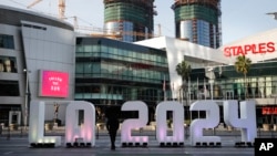 FILE - A Los Angeles 2024 sign stands in front of Staples Center, in Los Angeles, May 11, 2017. An International Olympic Committee panel has praised Los Angeles and Paris for “outstanding” plans to host the 2024 Summer Games.