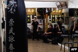 Dalam foto yang diambil pada 15 Juli 2023 ini, para siswa dan guru mengobrol di studio Asosiasi Atletik Sung Mo Wing Tsun di kawasan Sham Shui Po Hong Kong, menjelang peringatan 50 tahun kematian Bruce Lee, 20 Juli 2023. (May JAMES / AFP)