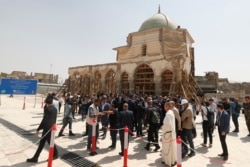 French President Emmanuel Macron (unseen) tours the Al-Nuri Mosque in Iraq's second city of Mosul, in the northern Nineveh province, on August 29, 2021.