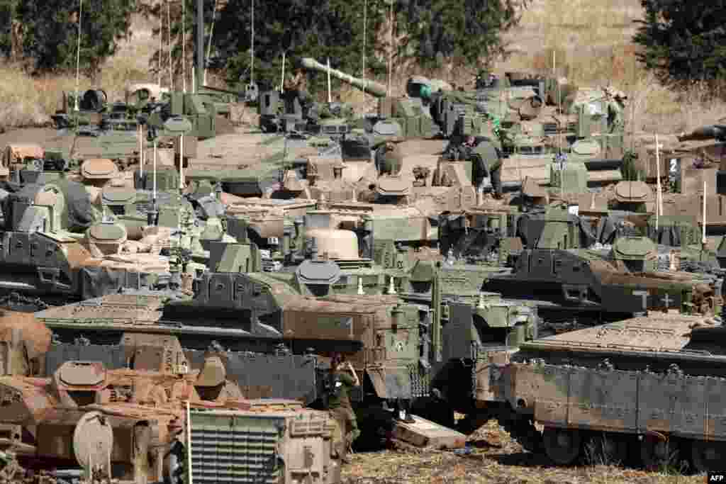 Israeli army tanks and armored vehicles are deployed in the Upper Galilee region of northern Israel near the border with Lebanon.