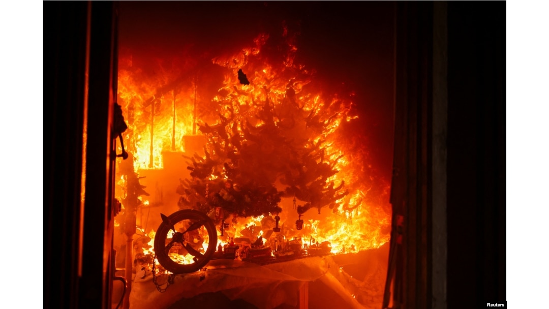 A Christmas tree burns as powerful winds fueling devastating wildfires in the Los Angeles area force people to evacuate, at the Eaton Fire in Altadena, California, Jan. 8, 2025.