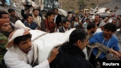 People carry the body of a woman they recovered from under the rubble of a house destroyed by a Saudi-led air strike in Sanaa, Yemen August 25, 2017. 