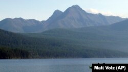  In this Sept. 6, 2013, file photo, Ingrid Forsmark kayaks on Kintla Lake in Glacier National Park, Mont.