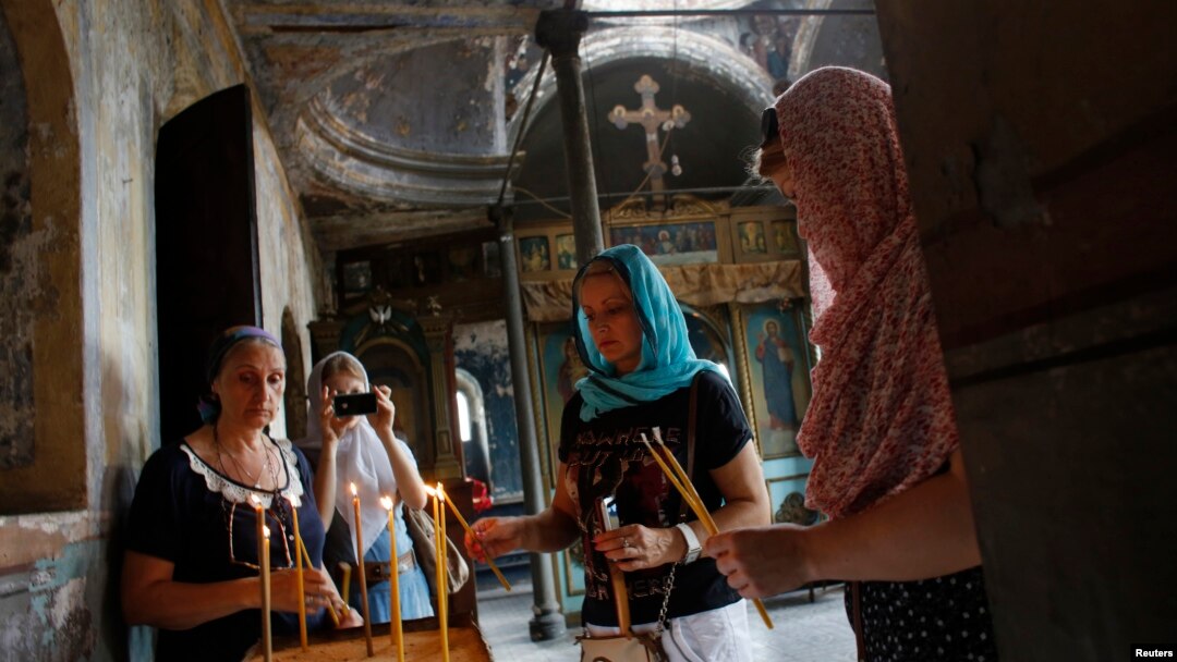 Anggota jemaat Rusia Ortodoks menyalakan lilin di Gereja St. Elijah di Istanbul (2/8). (Reuters/Murad Sezer)